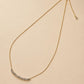 Full adjustable mixed-metal necklace displayed on a cream background, featuring a fine gold chain and movable silver beads.