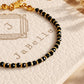 Black onyx beaded bracelet with tiny faceted black gemstones and delicate gold details displayed on a neutral jewellery card.