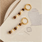 Flatlay of Tiger's Eye and Mother of Pearl beaded drop earrings shown on JaBelle logo packaging with size dimensions.