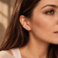 Woman wearing a minimalist gold enamel ear cuff on the cartilage with a clean everyday jewellery look.