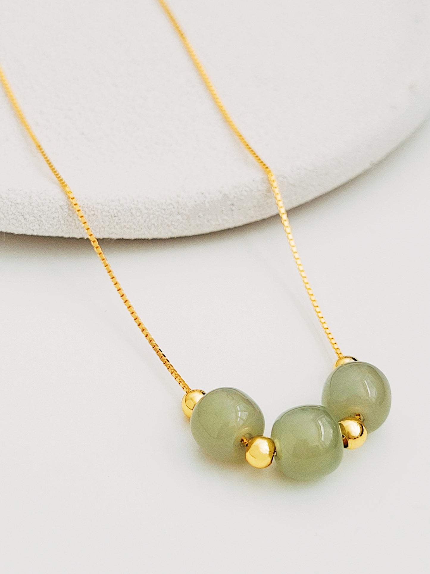 Elegant jade and gold vermeil pendant necklace on adjustable chain.