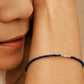 A dainty thin lapis lazuli beaded bracelet featuring tiny faceted blue bead gemstone interspersed with gold accents, perfect jewellery gift for September birthday girls