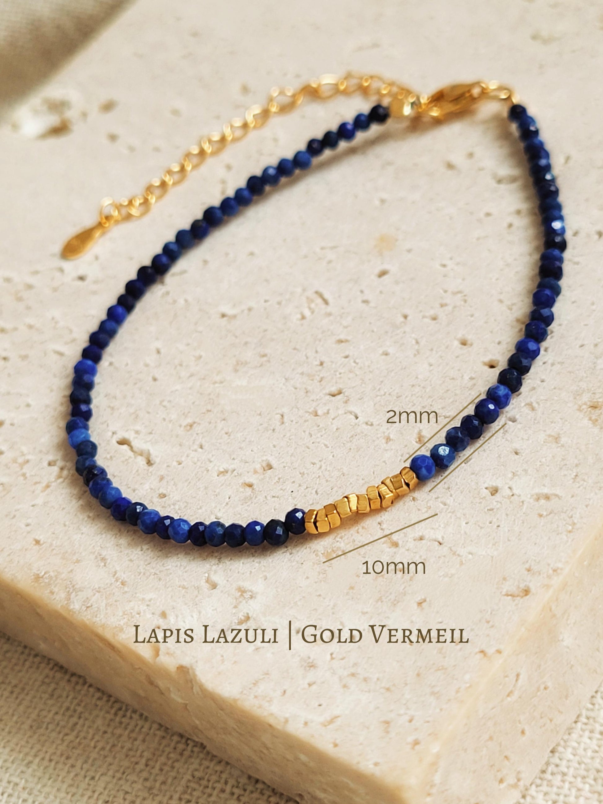 A deep blue lapis lazuli gemstone and gold bead bracelet featuring faceted natural stone beads and gold-plated accents.