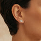 Close-up of a model wearing a dainty organic leaf-shaped stud earring in 18k gold vermeil, featuring a cluster of shimmering pave CZ diamonds against a neutral background.