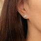 Close up of a woman wearing a silver stud earrings featuring natural leaf shape paved with cubic zirconia stone. 
