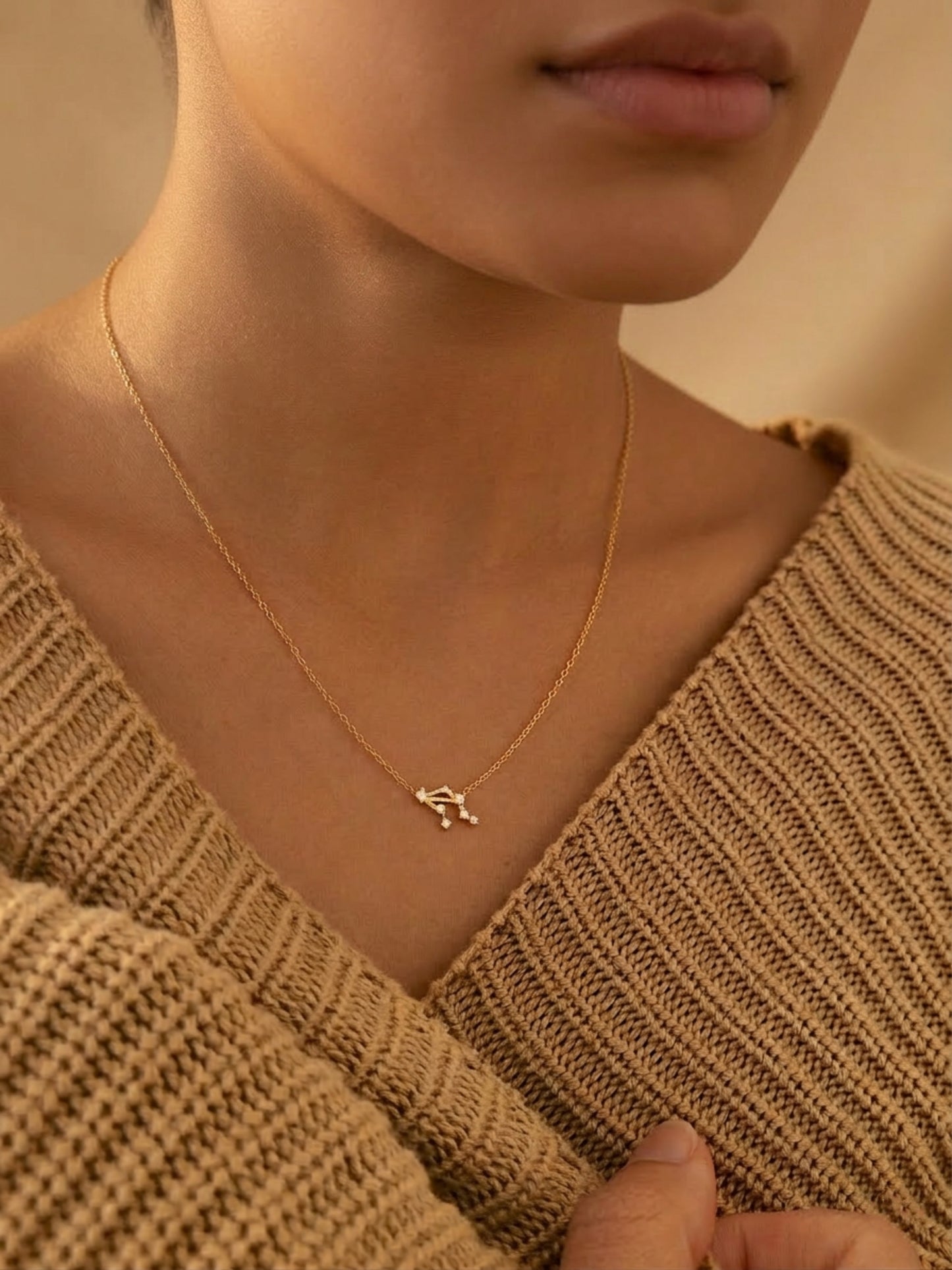 Close-up of a woman wearing a dainty gold Libra necklace showcasing the luxury aesthetic and pendant scale. Crafted in gold vermeil, perfect jewellery gift for her.