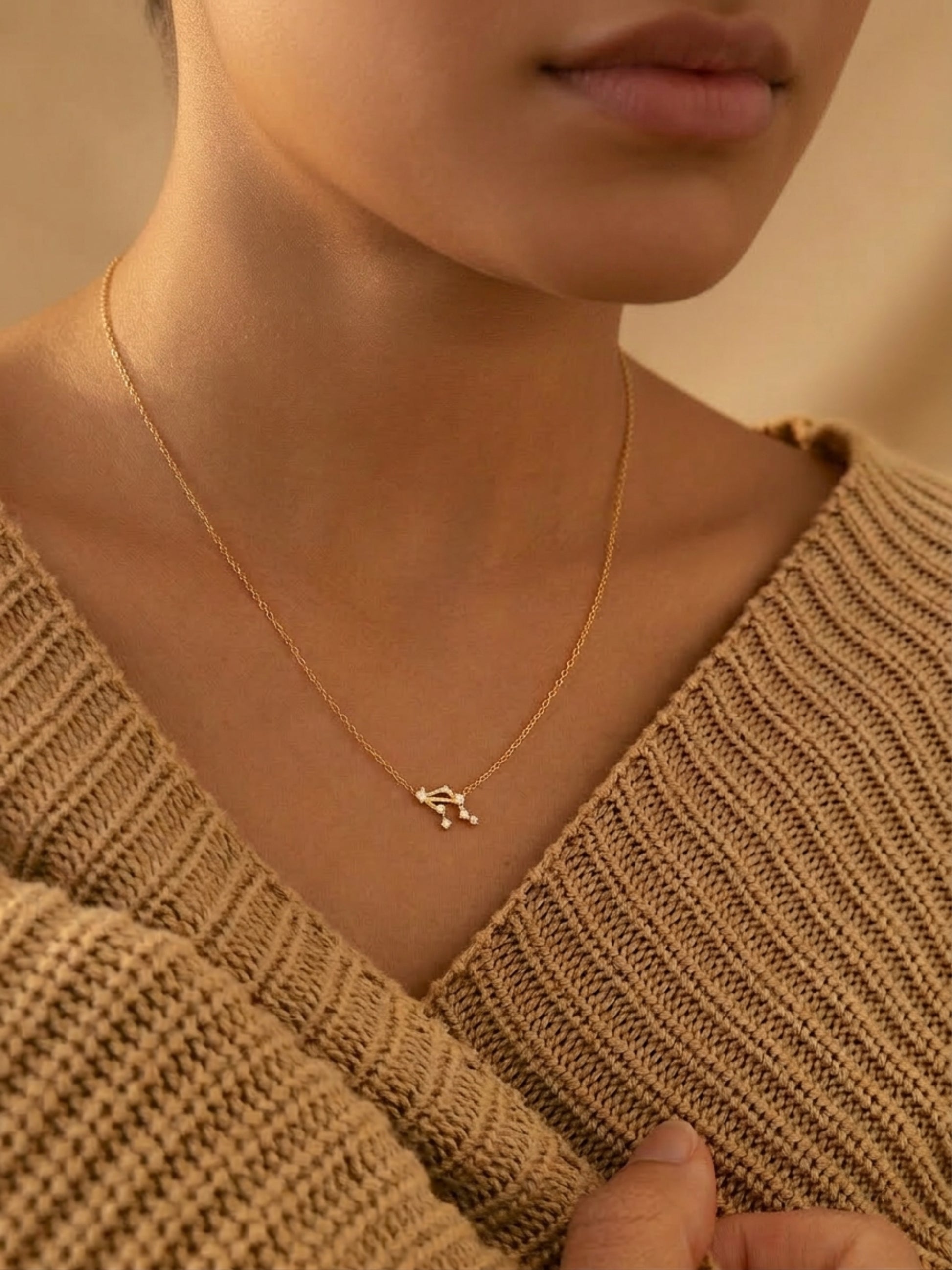 Close-up of a woman wearing a dainty gold Libra necklace showcasing the luxury aesthetic and pendant scale. Crafted in gold vermeil, perfect jewellery gift for her.
