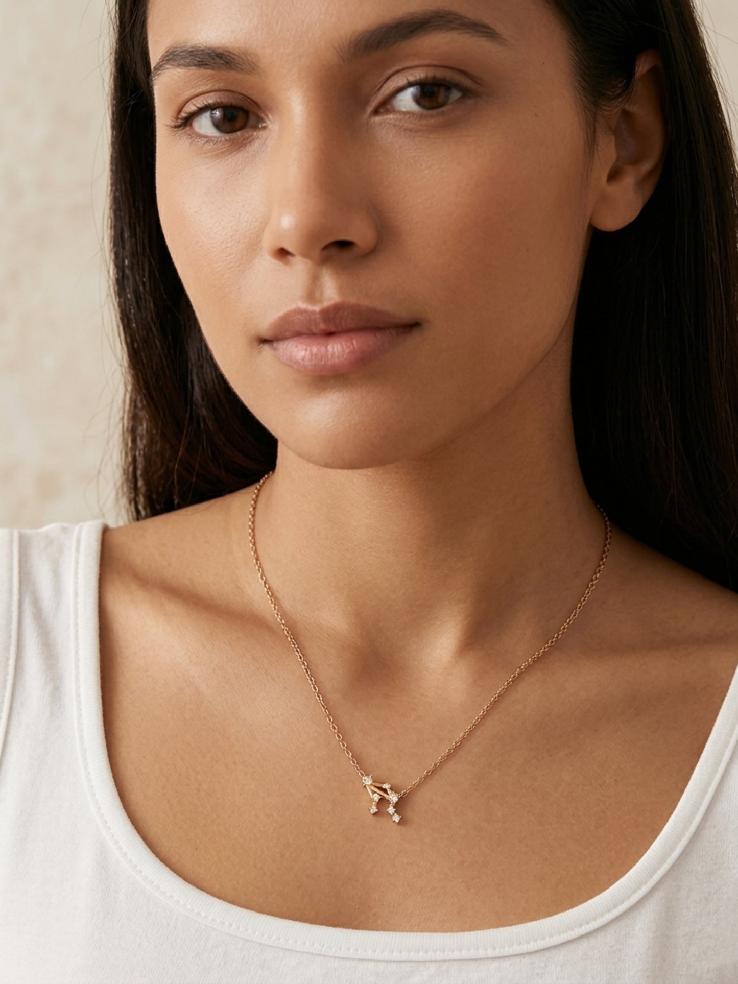 Close-up of a woman wearing a dainty gold Libra necklace showcasing the luxury aesthetic and pendant scale. Crafted in gold vermeil, perfect jewellery gift for her.