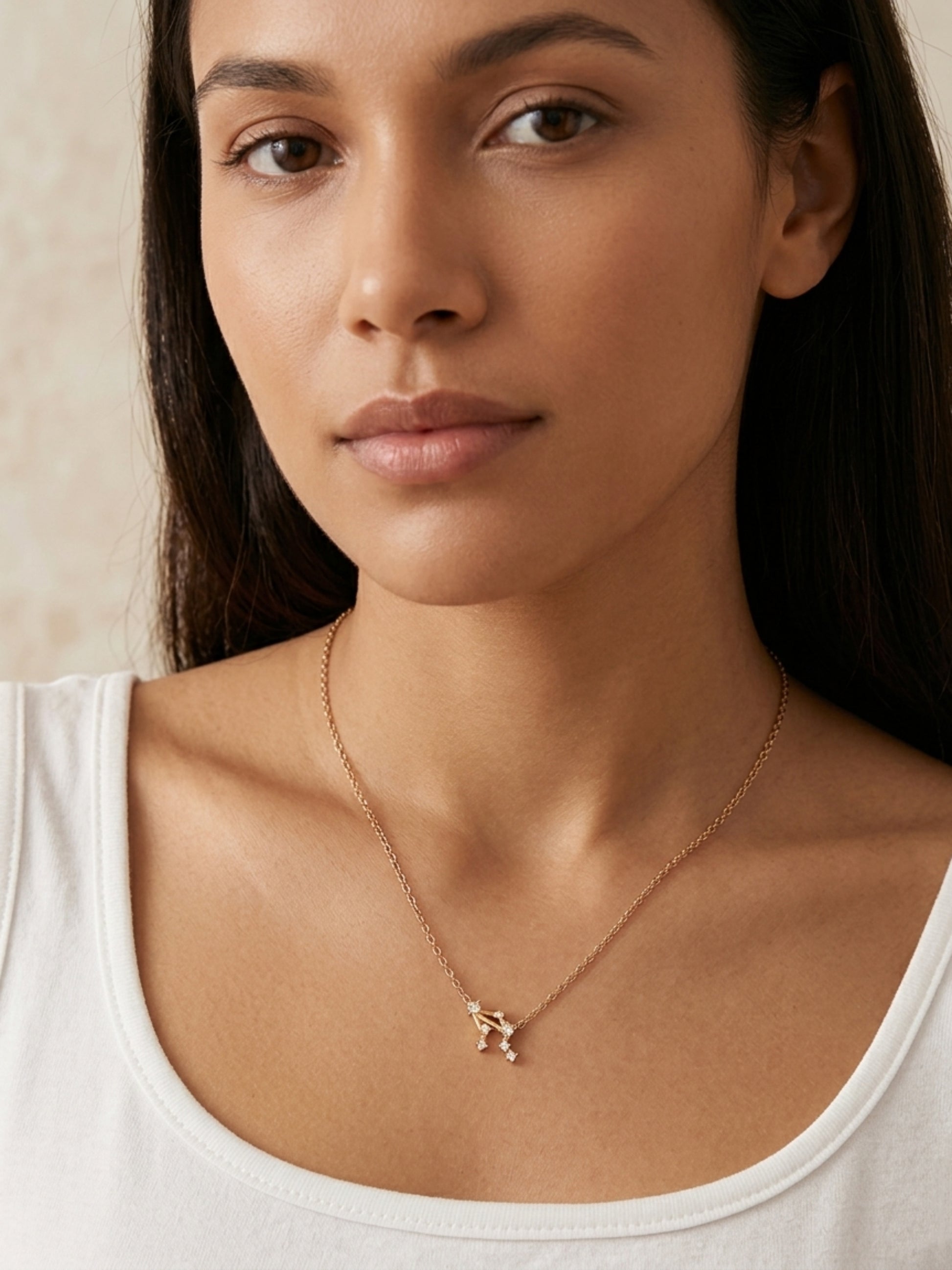 Close-up of a woman wearing a dainty gold Libra necklace showcasing the luxury aesthetic and pendant scale. Crafted in gold vermeil, perfect jewellery gift for her.