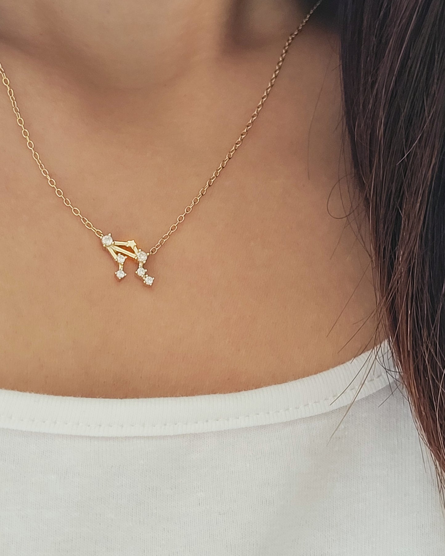 Close-up of a woman wearing a dainty gold Libra necklace showcasing the luxury aesthetic and pendant scale. Crafted in gold vermeil, perfect jewellery gift for her.