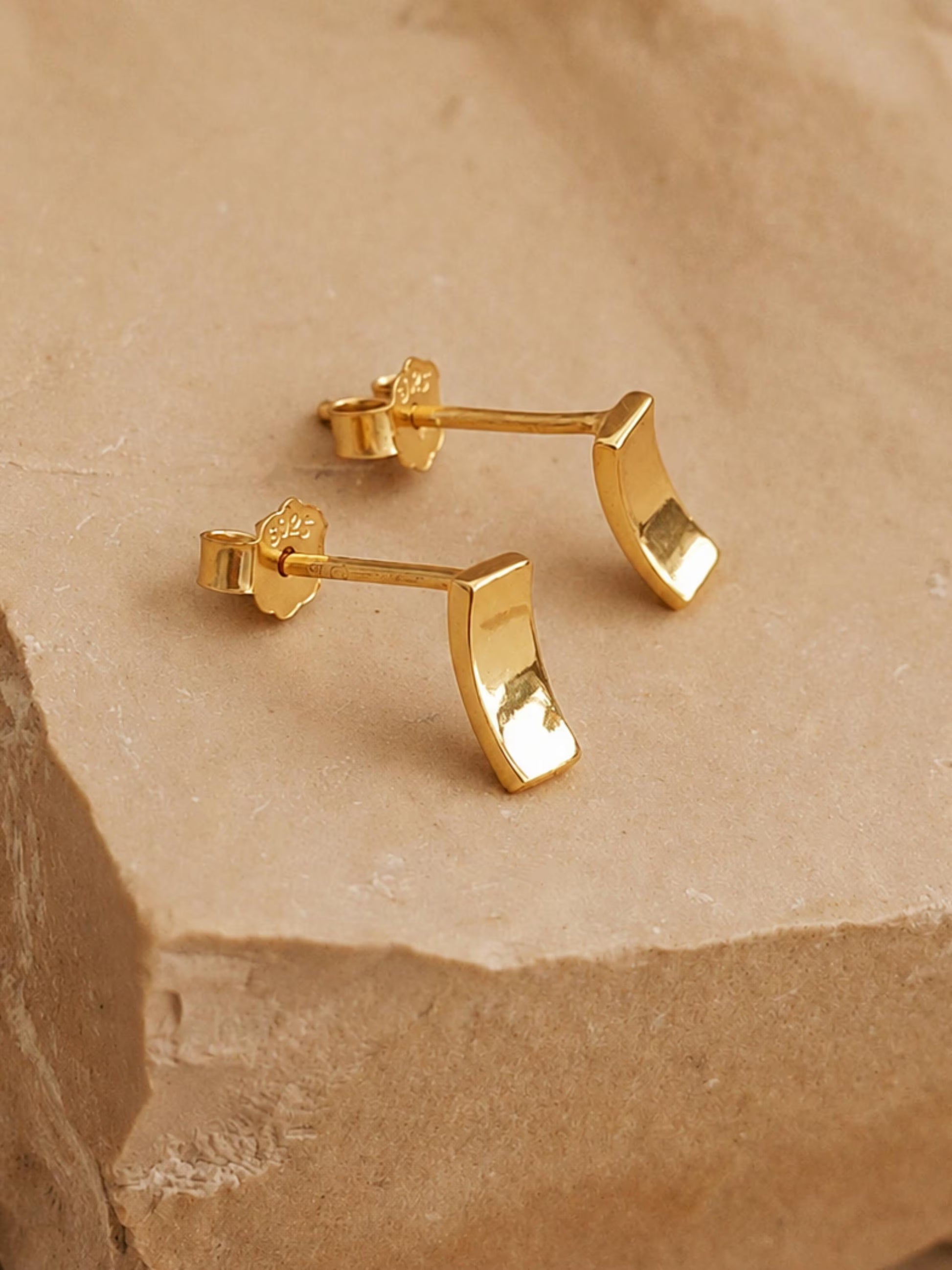 A pair of tiny gold stud earrings in curved bar shape crafted in gold plated sterling silver, dainty and minimal style.