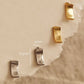 Gold and silver bar stud earrings, minimalist rectangle stud earrings in gold vermeil and sterling silver on an aesthetic beige color stone
