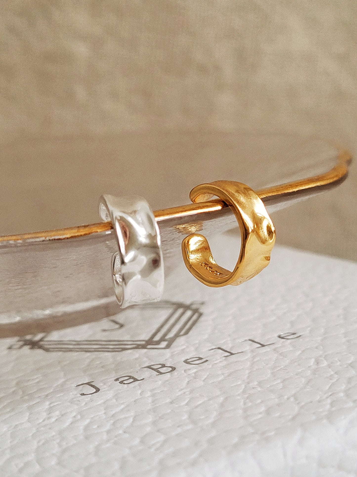 Gold and silver minimalist ear cuff earring hang on a plate