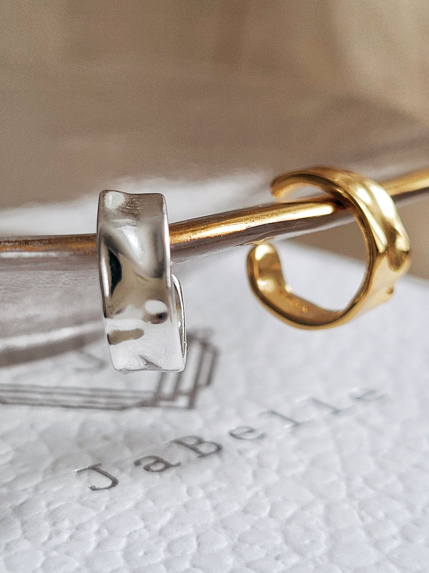 Close up of a hammered minimalist sterling silver cuff earring