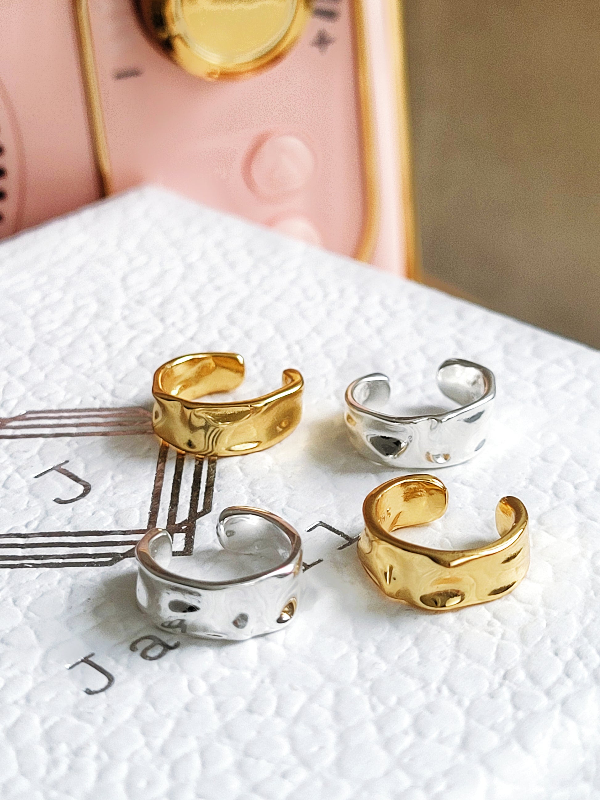 Four gold and silver ear cuff earrings  on a jewellery box