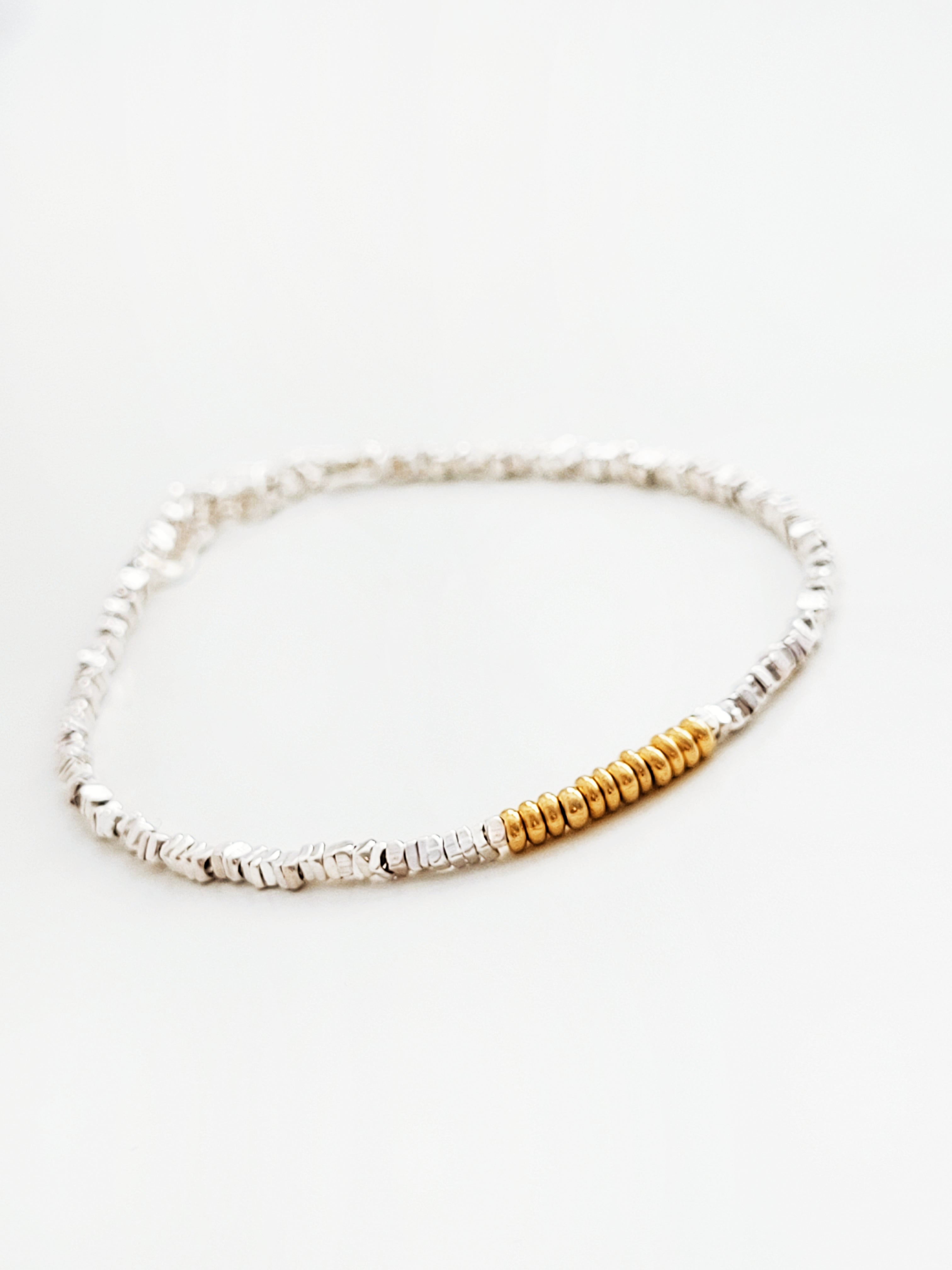 Bracelet with silver and gold beads on a white background
