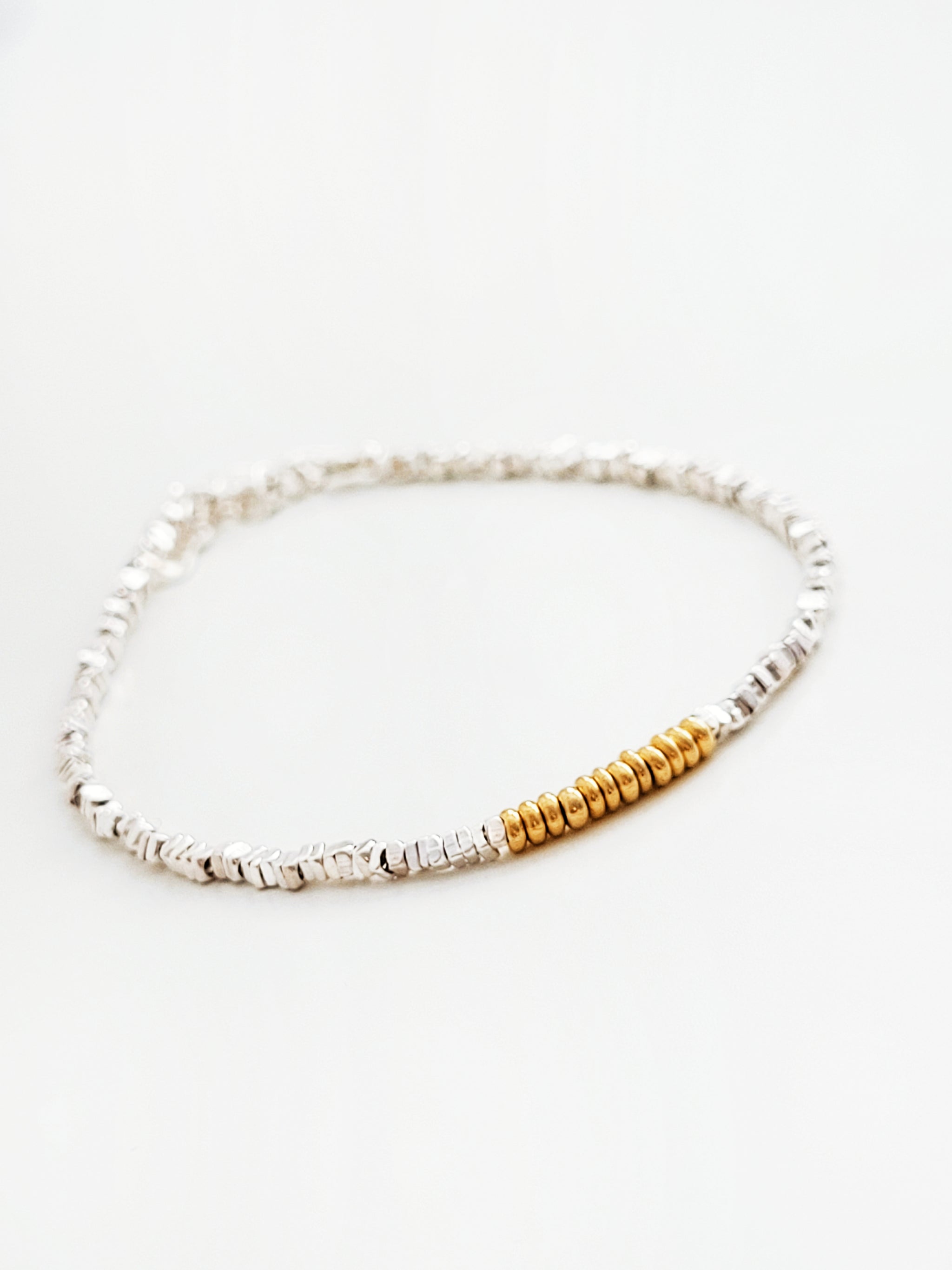 Bracelet with silver and gold beads on a white background