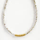 A minimalist mixed metal bracelet with alternating gold and silver beads on a white background