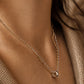 Woman wearing a dainty mixed metal double-chain necklace with a small round ring charm on her collarbone. Crafted in 18k gold plated sterling silver, minimalist and modern style jewellery.