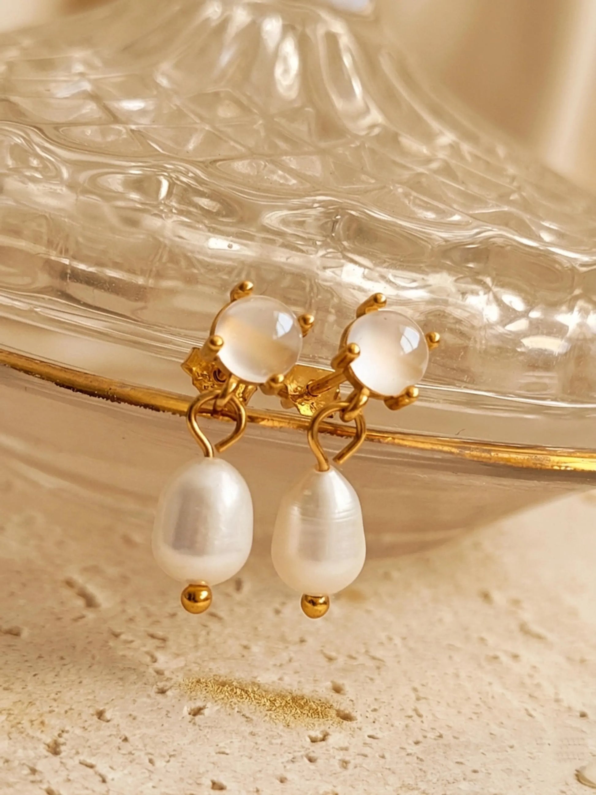 A pair of dainty gold stud earrings with moonstone and freshwater pearl drop crafted in 18k gold vermeil, minimalist wedding jewellery.
