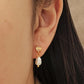Close up of a Moonstone stud earrings with freshwater pearl drop, crafted in 18k gold vermeil, dainty bridal jewellery in minimalist style.