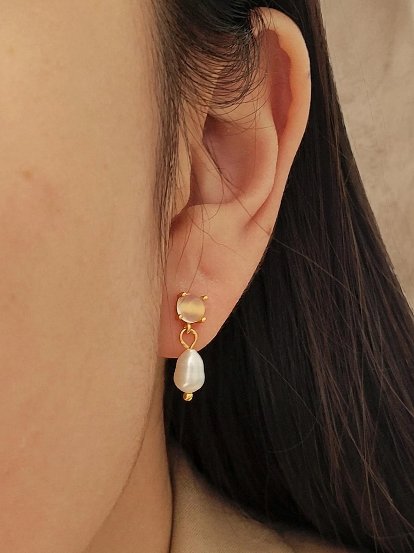 Close up of a Moonstone stud earrings with freshwater pearl drop, crafted in 18k gold vermeil, dainty bridal jewellery in minimalist style.