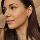 Woman with long dark hair wearing a moonstone stud earring featuring a dangly freshwater pearl drop, perfect birthday gift for june girl.