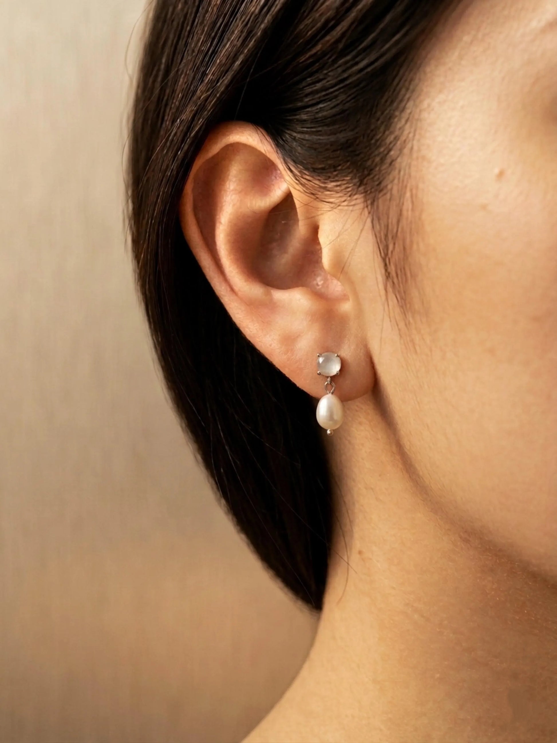 Dainty moonstone pearl drop earrings crafted in 925 sterling silver worn on a woman ear, minimalist bridal jewellery.
