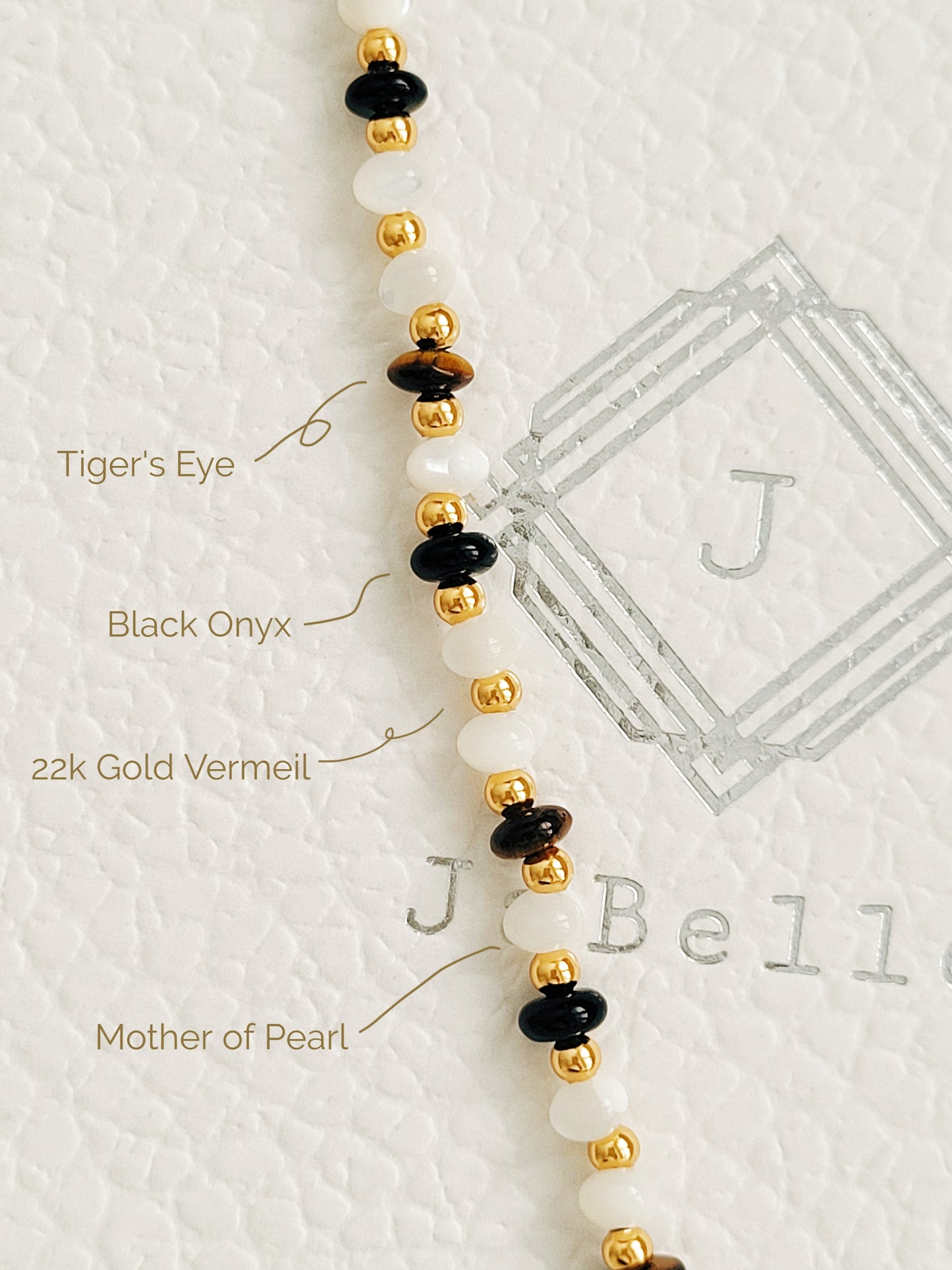 Details of a boho luxe bracelet featuring tiger's eye, mother of pearl, and black onyx beads with 22k gold vermeil accents