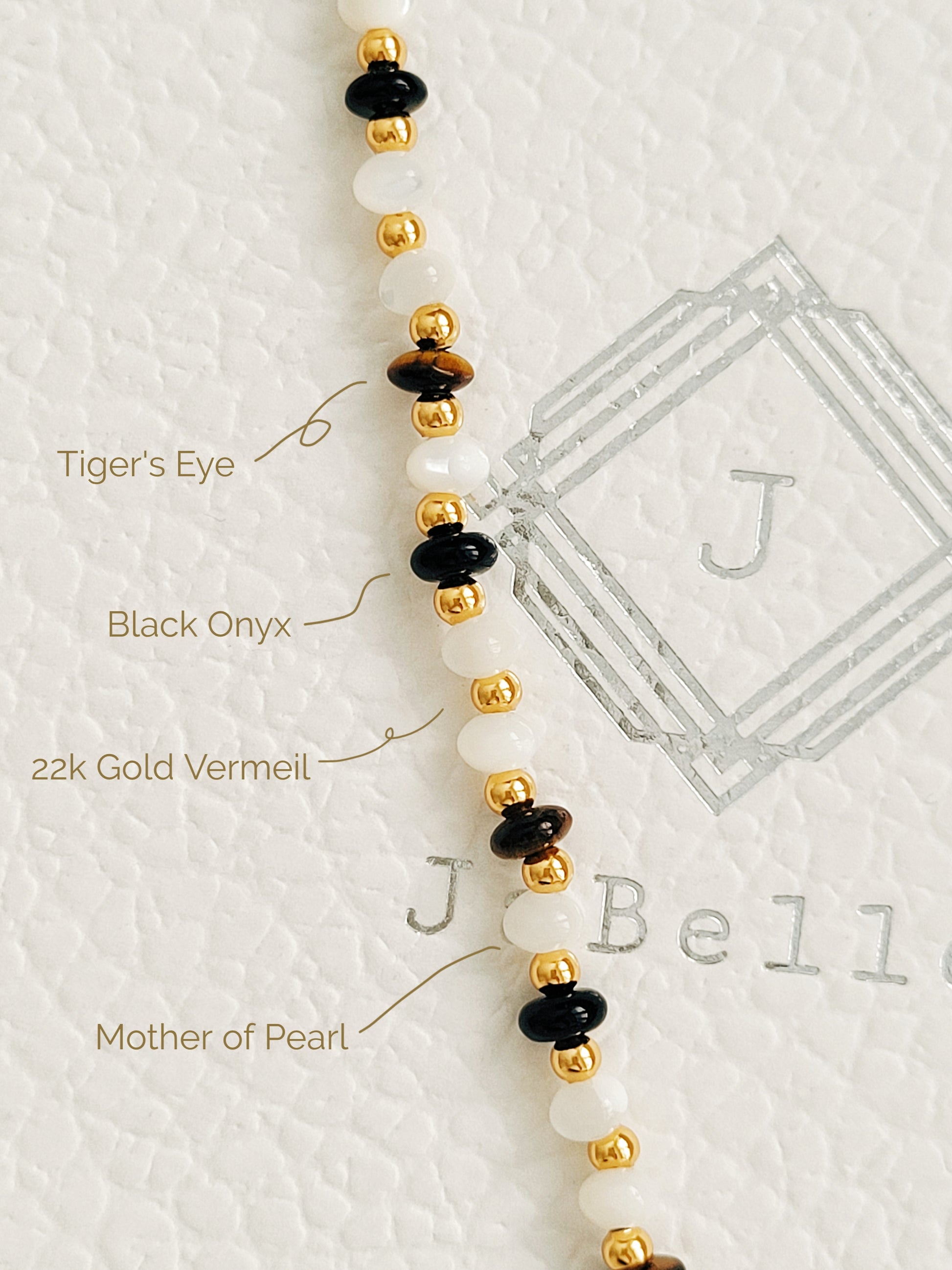 Details of a boho luxe bracelet featuring tiger's eye, mother of pearl, and black onyx beads with 22k gold vermeil accents
