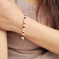 Model wearing a gemstone bracelet featuring in white, brown and gold color, showcasing its boho and luxe style