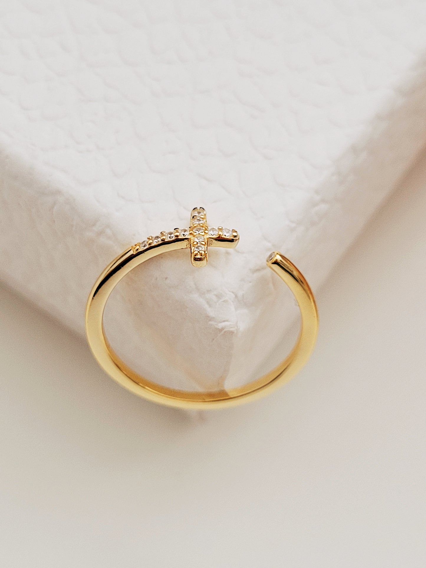 Elegant gold Cross ring adorned with brilliant zircons, showcasing timeless beauty and sophistication.