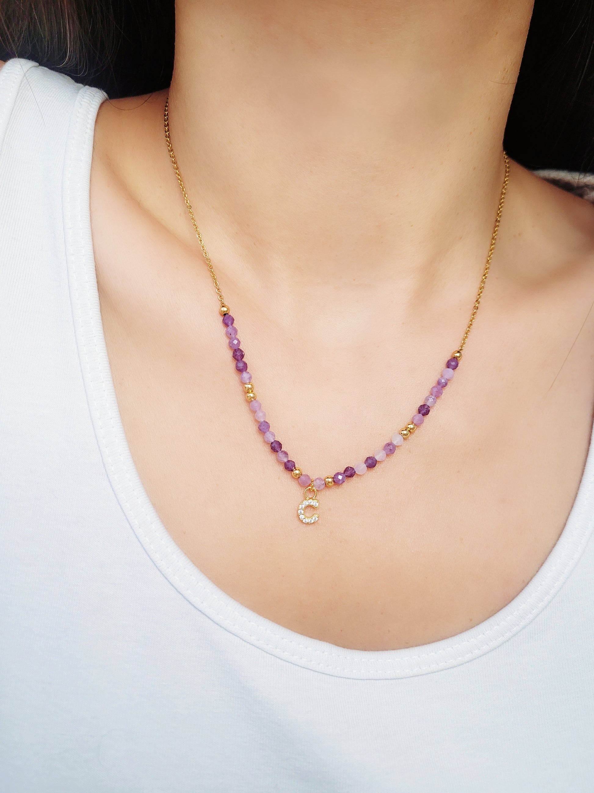 Close-up of a woman wearing the gold plated beaded amethyst necklace with customizable initial charms, showcasing delicate purple beads and adjustable chain. Perfect gift for birthday, anniversary or any occasions.