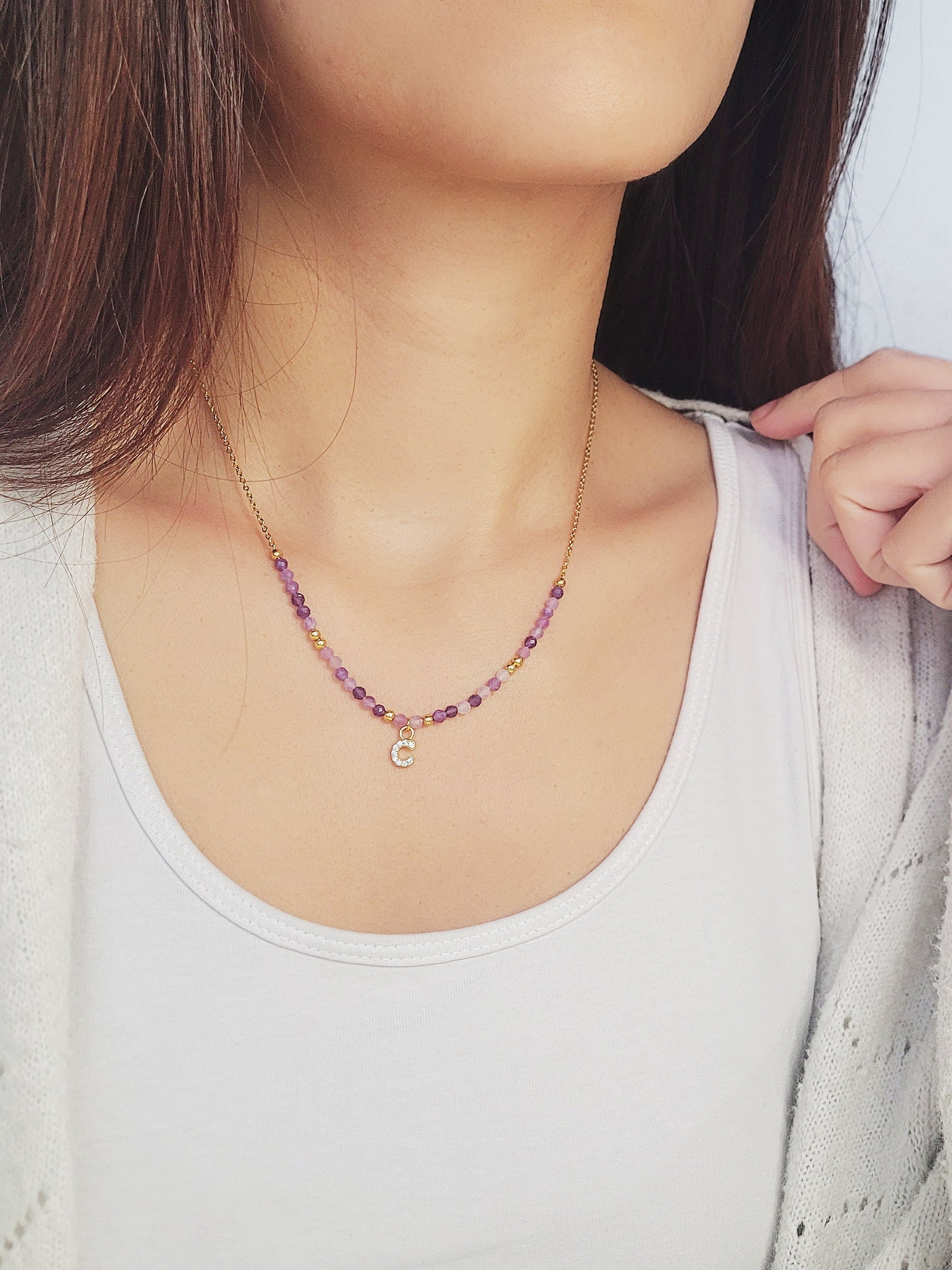 Close-up of a woman wearing the gold plated beaded amethyst necklace with customizable initial charms, showcasing delicate purple beads and adjustable chain. Perfect gift for birthday, anniversary or any occasions.