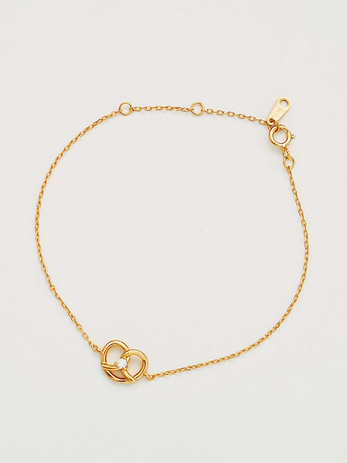 Stunning 18ct gold vermeil pretzel bracelet with a shimmering zircon at the center, show how much you love the sweet pretzel.