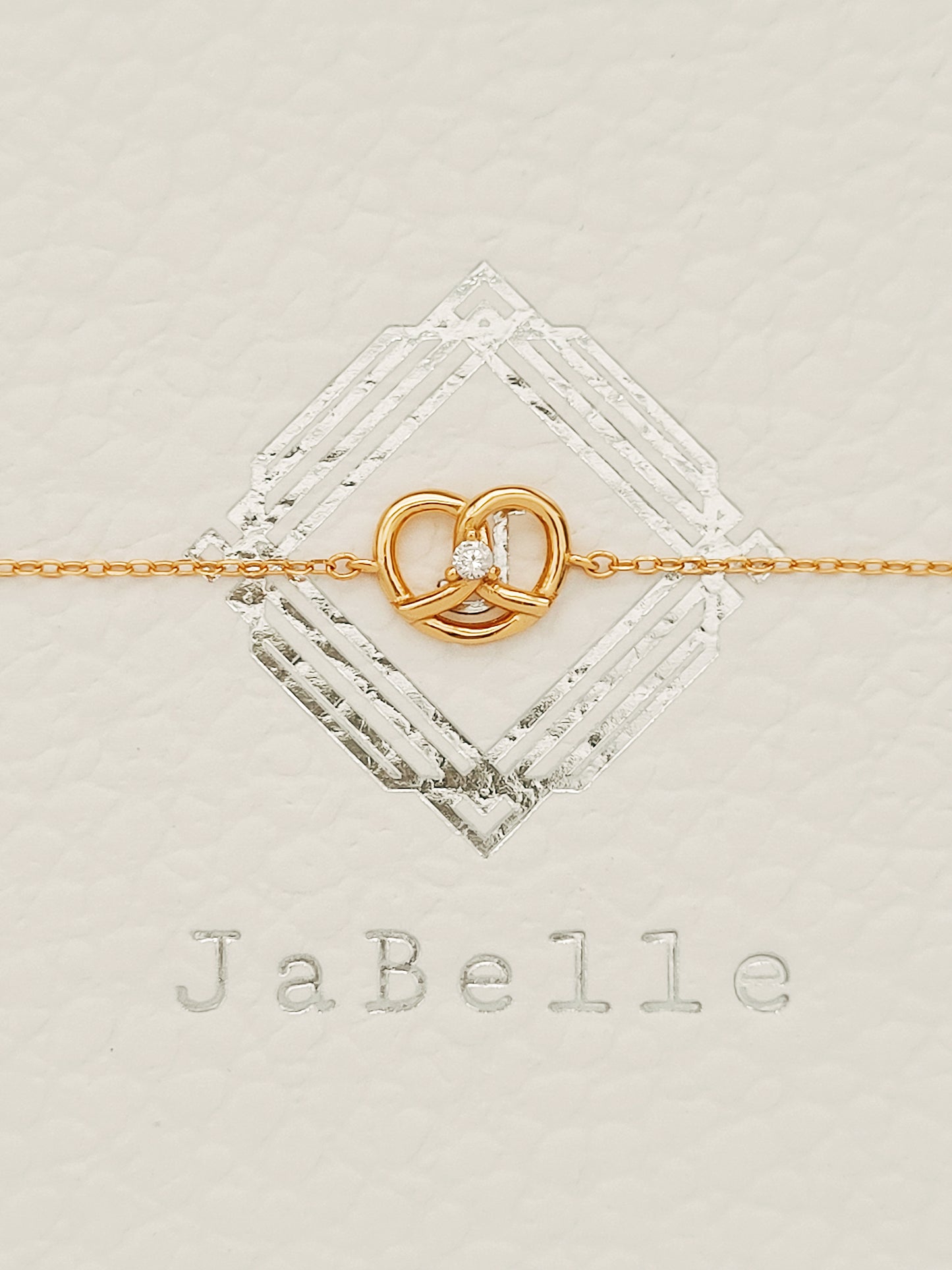 Exquisite 18ct gold-plated sweet pretzel bracelet adorned with a sparkling diamond, embodying elegance and luxury.