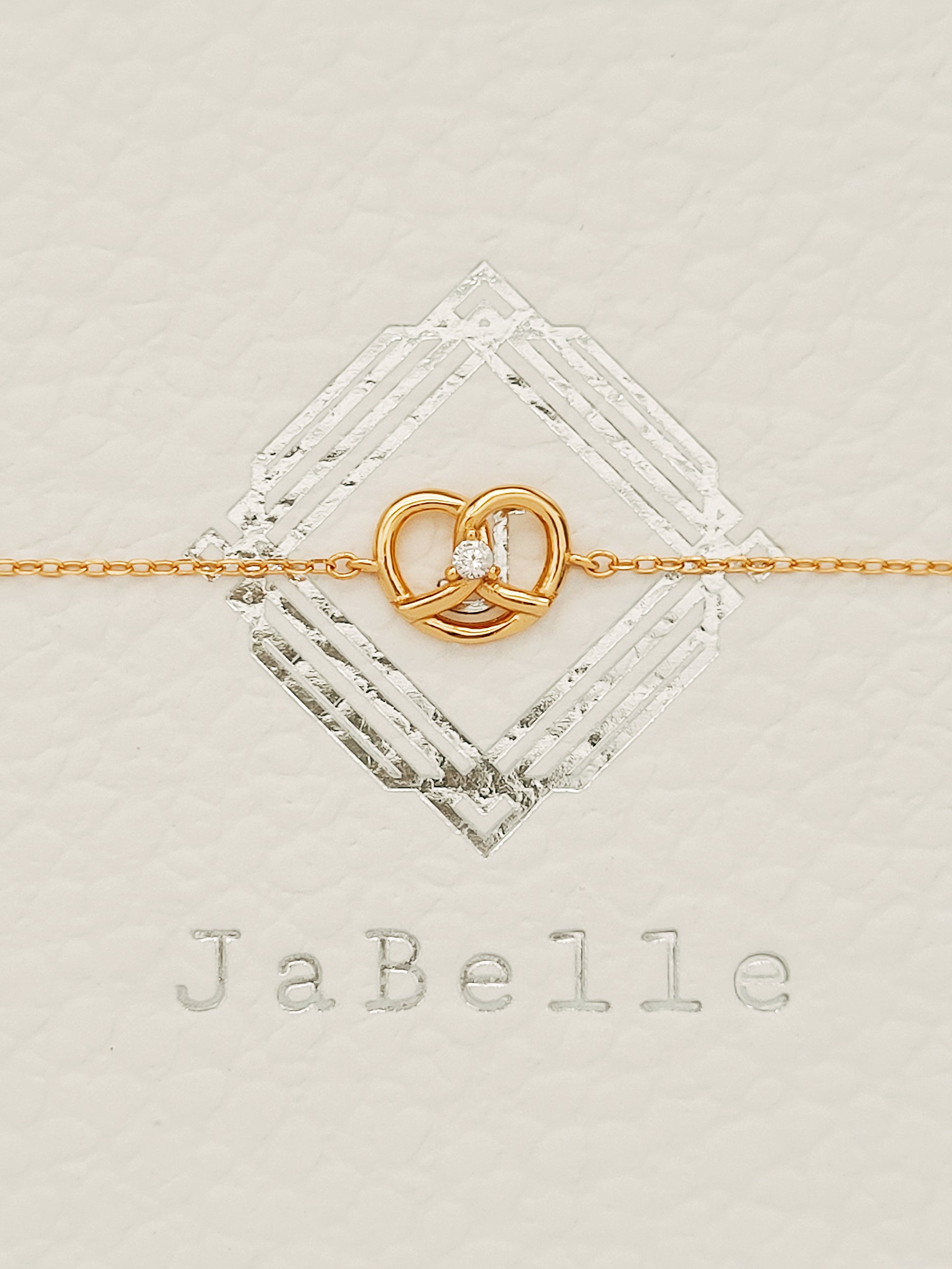 Exquisite 18ct gold-plated sweet pretzel bracelet adorned with a sparkling diamond, embodying elegance and luxury.