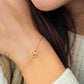 Close-up of a woman's hand gripping a beautiful gold pretzel bracelet, highlighting its intricate details and charm.