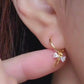 Close-up view of a woman&#39;s ear wearing gold ribbon bow earring with a dangling design, perfect for gifting to girlfriends, daughters, or loved ones.