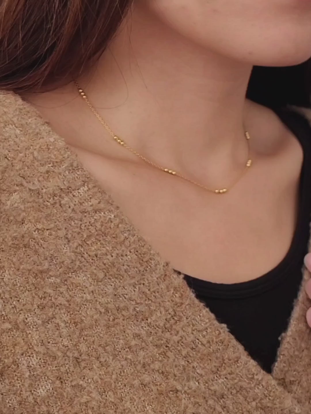 Close-up of a woman wearing a delicate 18ct gold vermeil triple ball necklace, showcasing its minimalist design with small gold beads spaced along a fine chain.