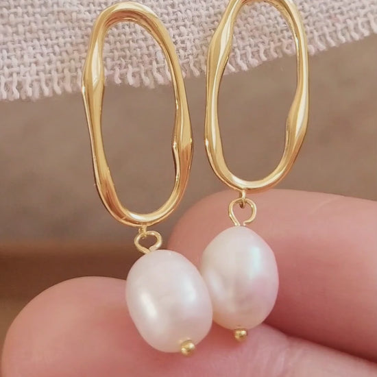 Woman wearing gold hoop earrings with freshwater baroque pearl drop for wedding.