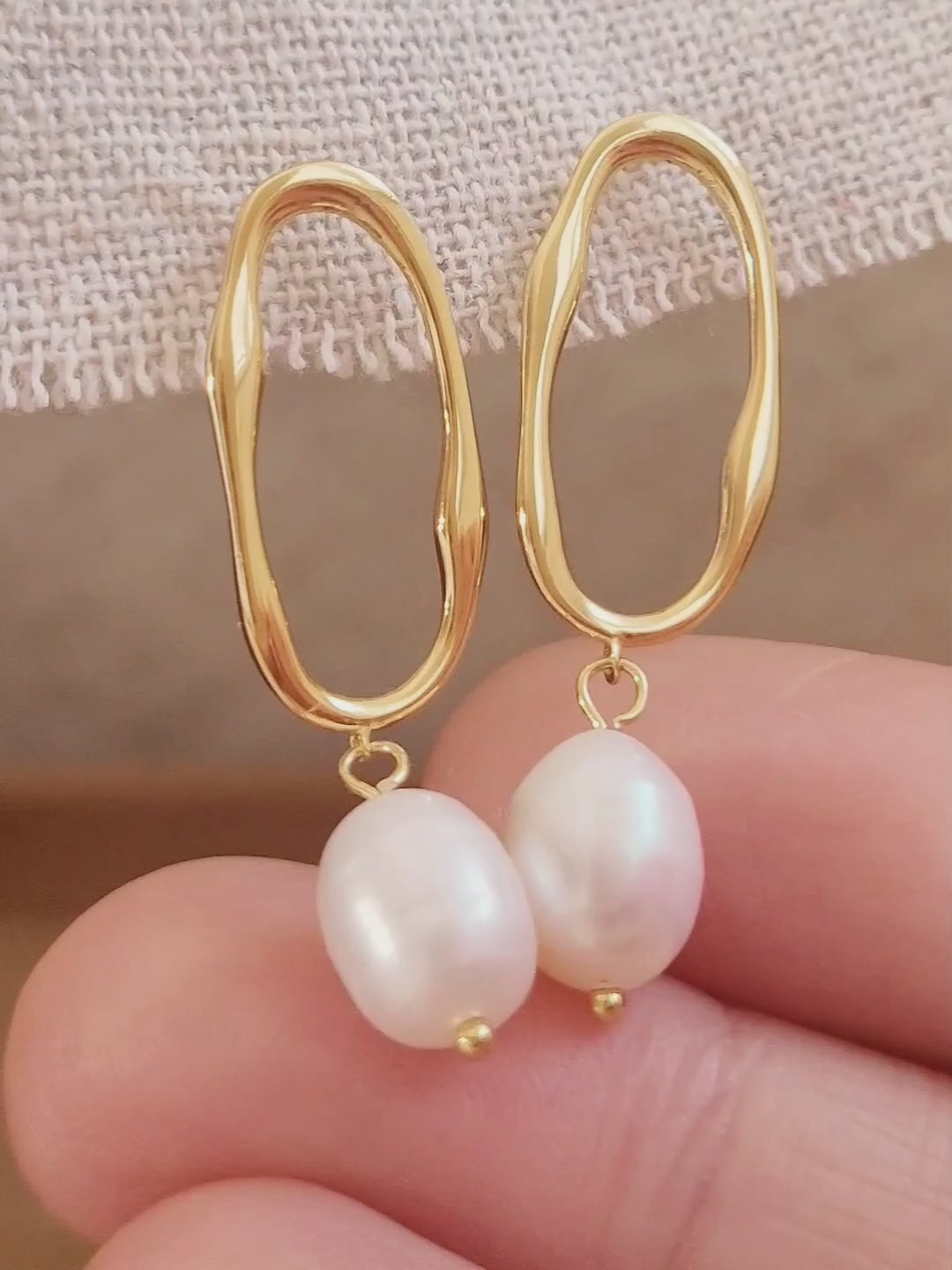 Woman wearing gold hoop earrings with freshwater baroque pearl drop for wedding.