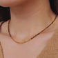Close-up of woman wearing Tiger’s Eye gemstone choker necklace with 22K gold vermeil nugget beads in natural sunlight