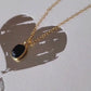 Minimalist black onyx pendant necklace with a gold-plated frame on a delicate chain.