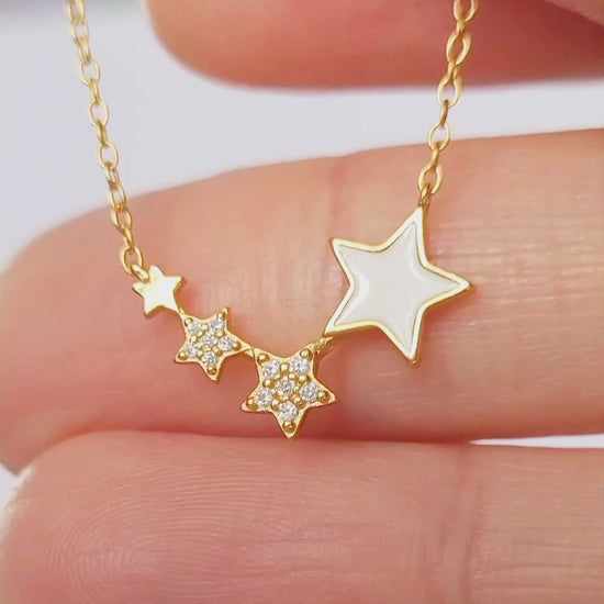 A refined woman wears a stunning gold necklace, accentuated by a delicate star, radiating charm and opulence.