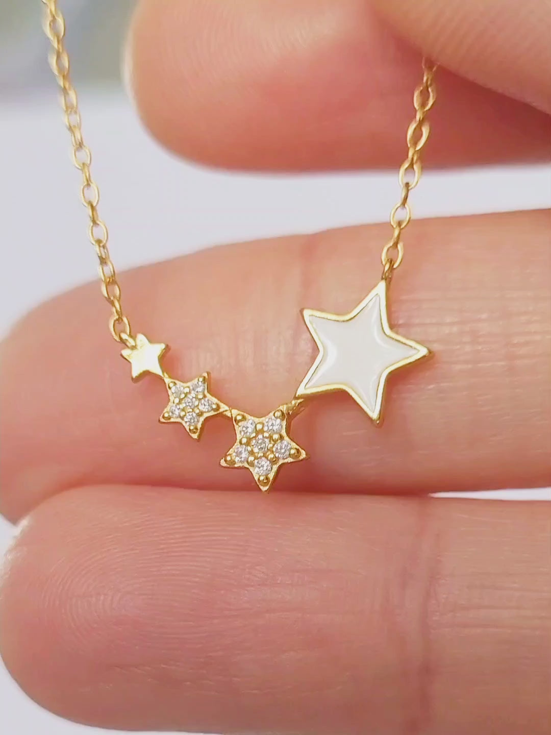 A refined woman wears a stunning gold necklace, accentuated by a delicate star, radiating charm and opulence.