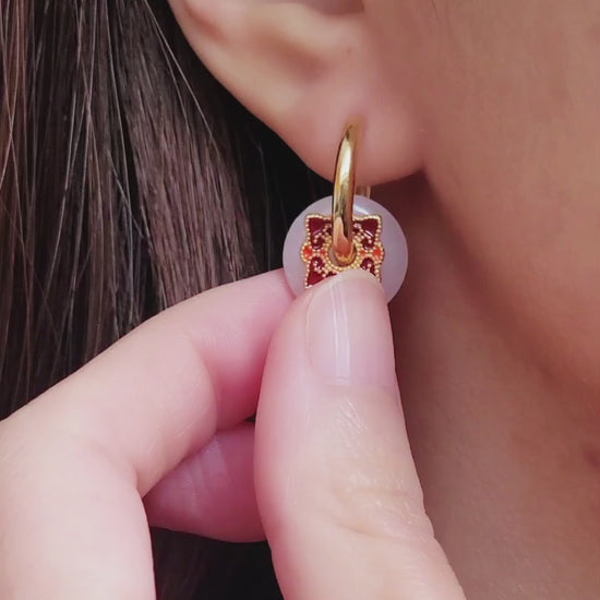 Close up of a woman’s ear wearing a stylish enamel charm earrings with boho flair, inspired by vintage tile designs and crafted for modern wear.