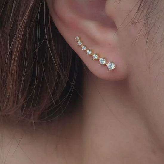 Close-up of a woman&#39;s ear wearing an 18K gold-plated cubic zirconia climber earring, highlighting the elegant and minimalist design.