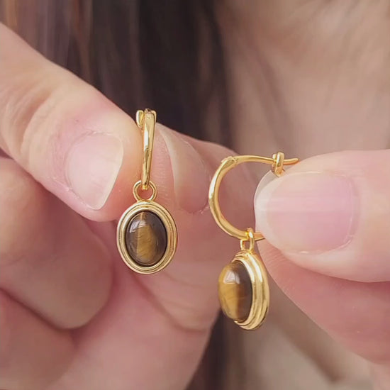 Close-up of gold vermeil dangle earrings with tiger's eye gemstone, minimalist and elegant style