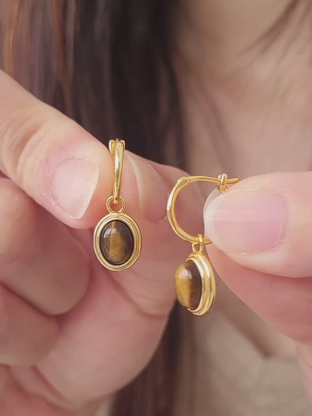 Close-up of gold vermeil dangle earrings with tiger's eye gemstone, minimalist and elegant style